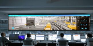 Operatorzy w nowoczesnej sterowni monitorujący cyfrowe ekrany systemów