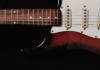 Zbliżenie na elektryczną gitarę solową na ciemnym tle