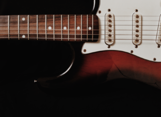 Zbliżenie na elektryczną gitarę solową na ciemnym tle