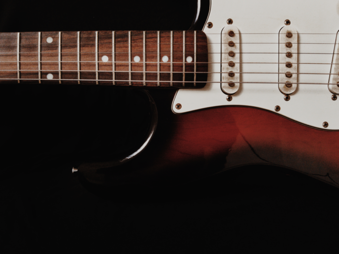 Zbliżenie na elektryczną gitarę solową na ciemnym tle