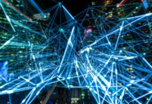 Czy internet rzeczy uczyni nasze miasta naprawdę inteligentnymi Nocna panorama miasta z świetlnymi smugami symbolizującymi sieci IoT