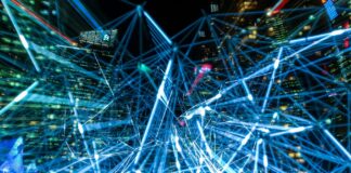 Nocna panorama miasta z świetlnymi smugami symbolizującymi sieci IoT