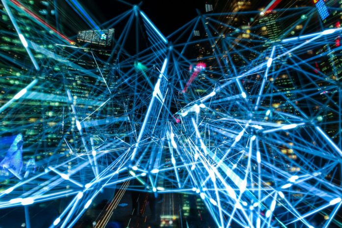 Nocna panorama miasta z świetlnymi smugami symbolizującymi sieci IoT Nocna panorama miasta z świetlnymi smugami symbolizującymi sieci IoT