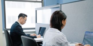 Dwoje profesjonalistów pracuje na laptopach w nowoczesnym biurze