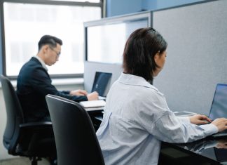 Jak narodziły się serwisy społecznościowe i dlaczego pierwszy Facebook nie był pierwszy Dwoje profesjonalistów pracuje na laptopach w nowoczesnym biurze
