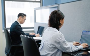 Dwoje profesjonalistów pracuje na laptopach w nowoczesnym biurze