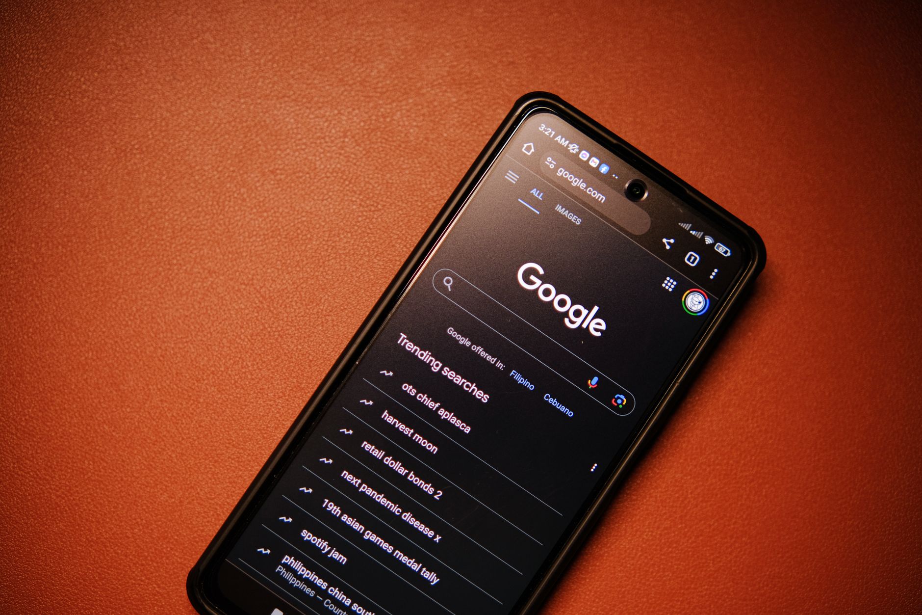 Smartfon z wynikami trendów wyszukiwania Google na stole nocą